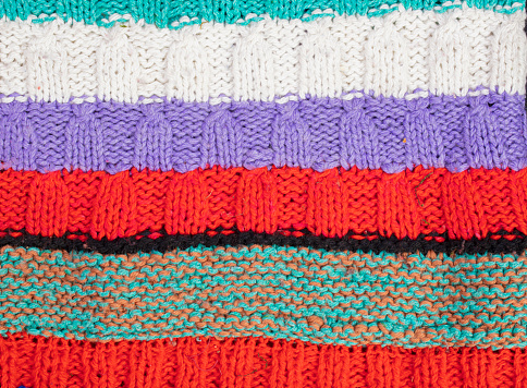 Knitted multi-colored texture. Background knitted product close-up.