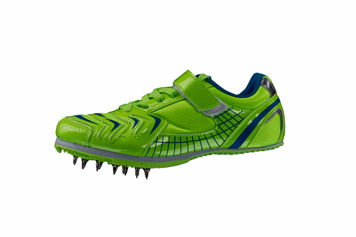 Zapatilla verde brillante con púas sobre fondo blanco. Zapatos deportivos. photo