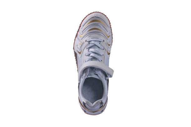 Vertical white sneaker with gilded accents on a white background