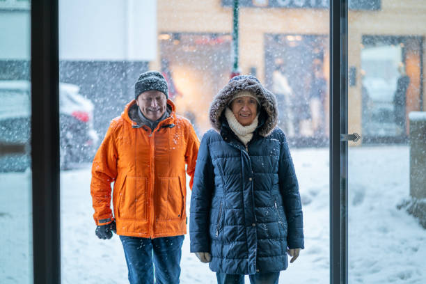 szczęśliwi seniorzy wracający ze spaceru w śniegu przed hotelem w ośrodku narciarskim - ski resort village austria winter zdjęcia i obrazy z banku zdjęć