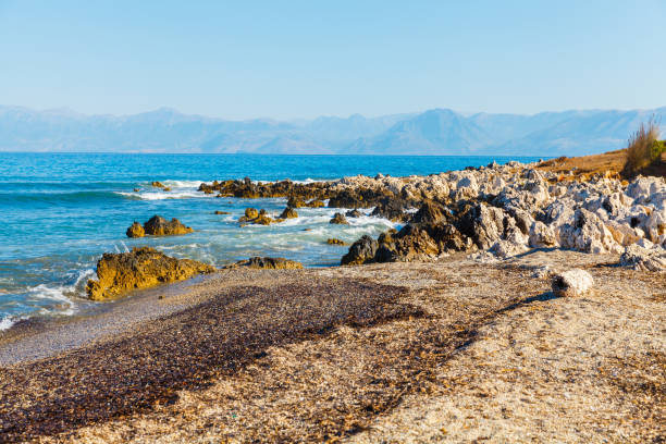 rocky beach on the island of corfu - travel destinations rocky coastline moody sky clear sky imagens e fotografias de stock