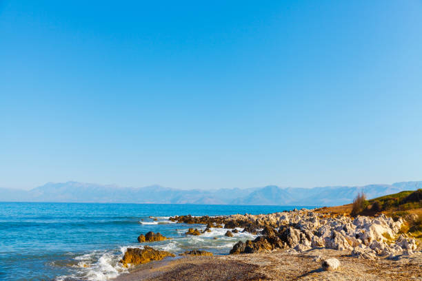 rocky beach on the island of corfu - travel destinations rocky coastline moody sky clear sky imagens e fotografias de stock