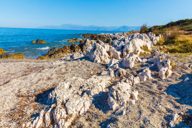 rocky beach on the island of corfu - travel destinations rocky coastline moody sky clear sky imagens e fotografias de stock