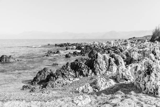 skalista plaża na wyspie korfu - travel destinations rocky coastline moody sky clear sky zdjęcia i obrazy z banku zdjęć