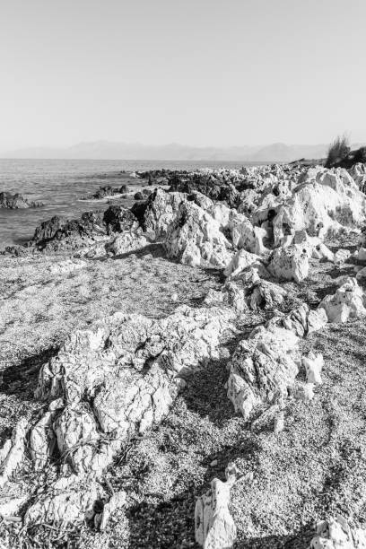 rocky beach on the island of corfu - travel destinations rocky coastline moody sky clear sky imagens e fotografias de stock