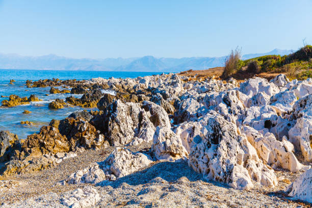 rocky beach on the island of corfu - travel destinations rocky coastline moody sky clear sky imagens e fotografias de stock