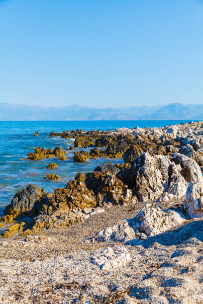 rocky beach on the island of corfu - travel destinations rocky coastline moody sky clear sky imagens e fotografias de stock