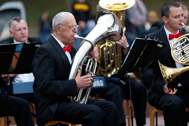. 한 노인 뮤지션이 관악기를 타고 연주합니다. 오케스트라에서 재생합니다. 음악가 남자 - jazz music trumpet valve 뉴스 사진 이미지
