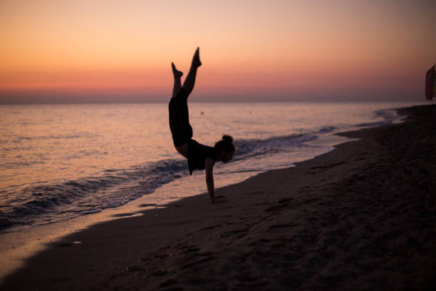 istock Girl dancing on the beach at sunset 1197261773