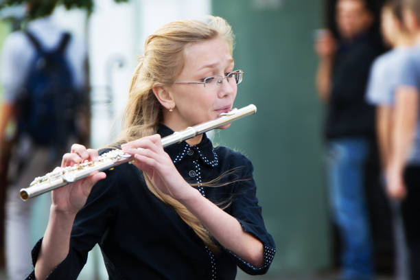 Belarus, Gomel, September 16, 2017. Celebrating the city day.The musician is playing the flute. A young girl blows a flute. Playing the flute