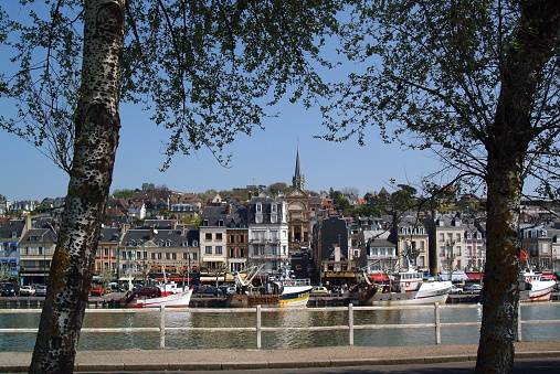 September 29th. 2019. Trouville-sur-Mer, commonly referred to as Trouville, is a commune in the Calvados department in the Normandy region in northwestern France. Trouville-sur-Mer borders Deauville. This village of fishermen is a popular tourist attraction in Normandy. This is an image of the port and marina with moored boats. There are boat owners and tourists in the distance on a bright sunny day in late summer. There are leisure and fishing boats in the picture.