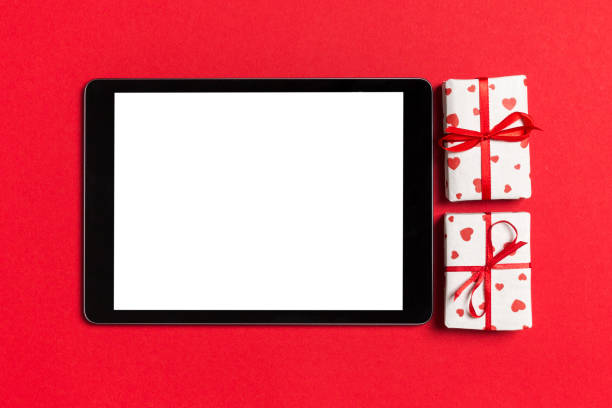istock Top view of digital tablet surrounded with gift boxes on colorful background. Saint Valentine's day 1197264361