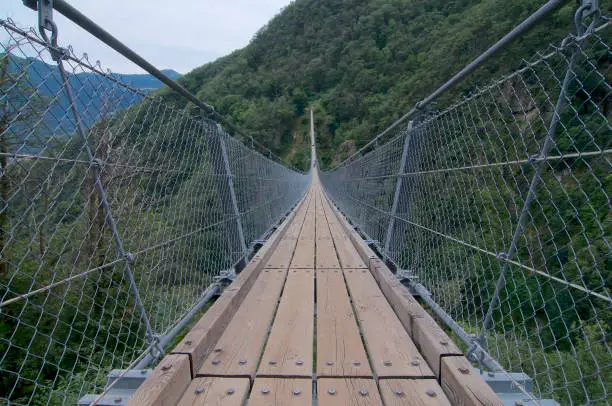 View of the 270m long Tibetan bridge "Carasc" that allows the passage of the rugged valley that separates the communities of Sementina and Monte Carasso in the Canton Ticino in Switzerland
