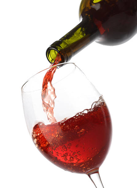 istock Pouring red wine into a glass isolated on white 119726569