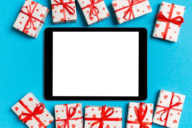 istock Top view of digital tablet surrounded with gift boxes on colorful background. Saint Valentine's day 1197265918