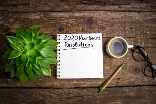 istock New year resolutions 2020 on desk. 2020 goals list with notebook, coffee cup and eyeglasses on wooden background. Goal, plan, strategy, change, idea concept 1197266067