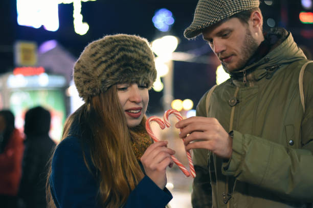 istock beautiful young couple making heart with lollipop 1197267326