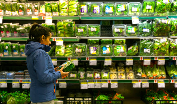 Woman looking at fresh vegetables in the supermarket stock photo stock photo