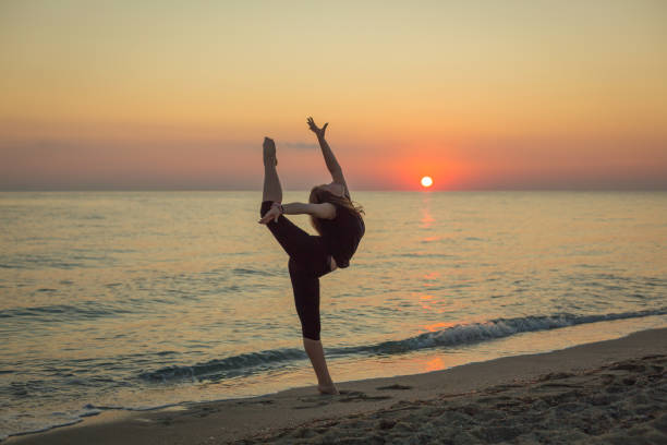 istock Girl dancing on the beach at sunset 1197270507
