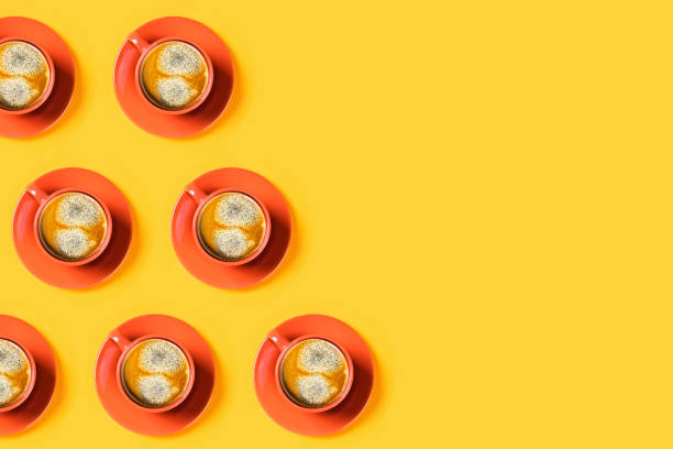 istock Cups of coffee on yellow background. 1197270531