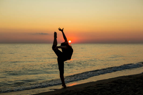 istock Girl dancing on the beach at sunset 1197270652