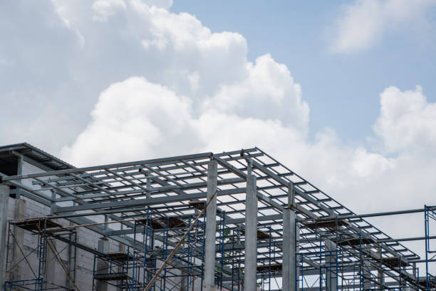 istock Building and Construction Site in progress. Building construction site against cloudy sky. Metal construction of unfinished building on construction of multi storage building. 1197271037