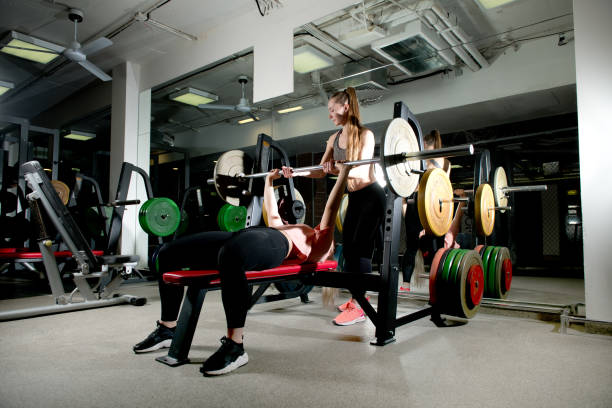 istock girl insures her friend while she does the bench press on the bench 1197271085