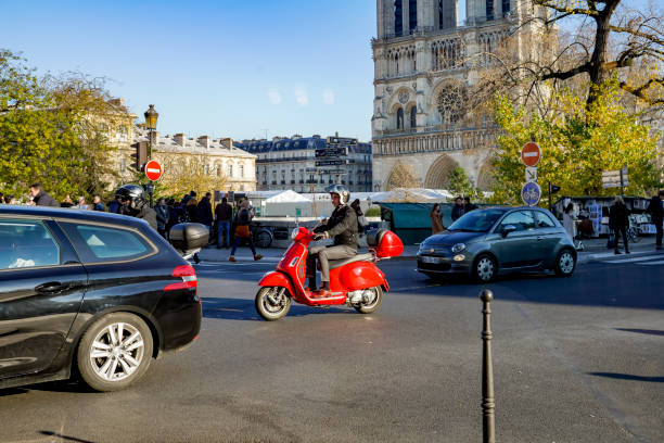 2019 The River Seine Pont St Louis in Paris with traffic and a red motor scooter in the foreground.