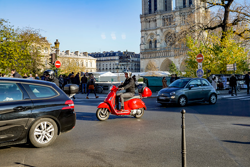 2019 The River Seine Pont St Louis in Paris with traffic and a red motor scooter in the foreground.