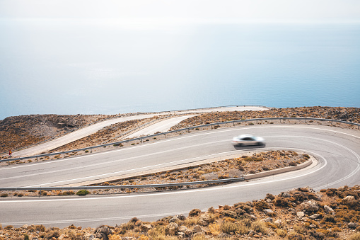 Car driving on a winding mountain road (south Chania region, Crete, Greece).