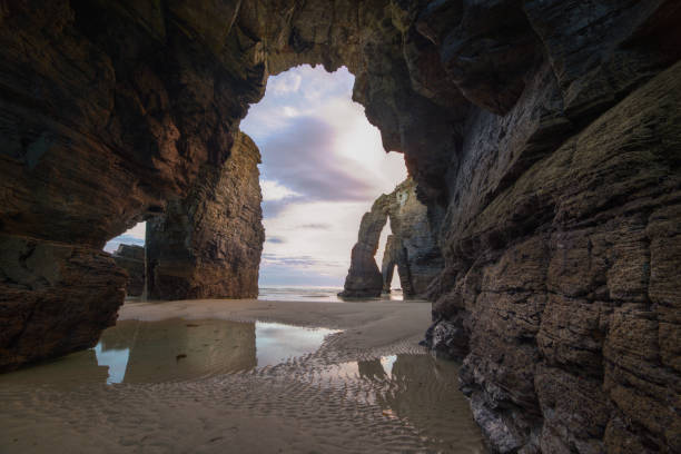 istock Sunrise at sea framed by a rock arch 1197273716