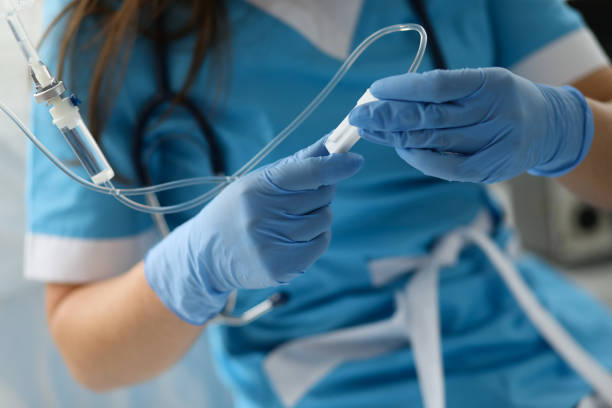 mano de enfermera femenina en guantes de protección azul sostener gotero - medical equipment stethoscope hospital blue fotografías e imágenes de stock