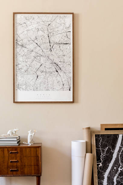 istock Modern scandinavian living room interior with mock up poster frame, design retro commode, maps, lamp, books and elegant accessories. Beige wall. Japandi. Template. Stylish home decor. 1197278490