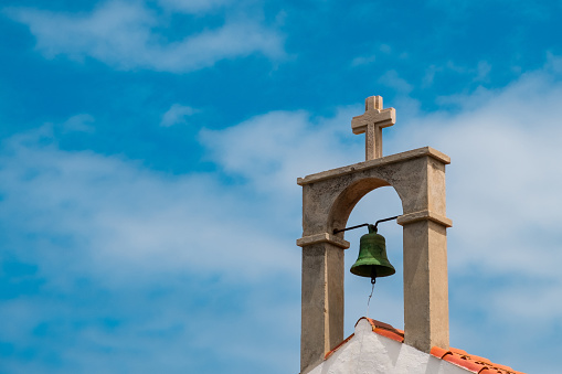 Tower and cross of an orthodox church against the blue sky on a sunny day.
