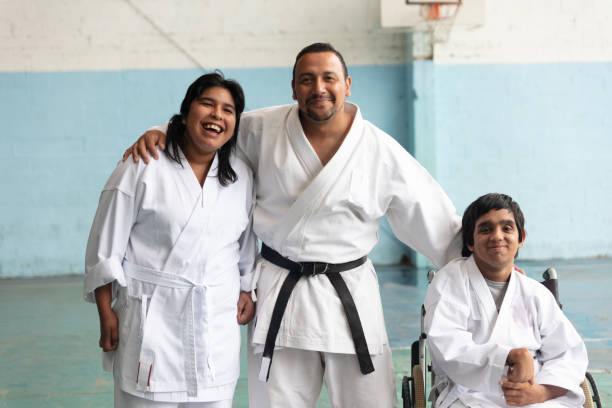 istock Portrait of parakarate teacher with 2 disable students, all smiling 1197281153