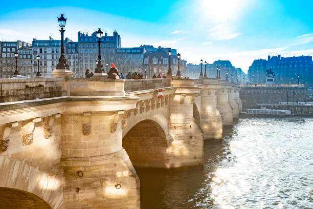 2019 Streetlights on Pont de Arts with sidelit stone arches. In the background is the  Centre des monuments Nationaux  Paris, France.
