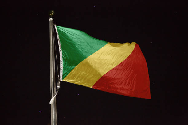 bandiera della repubblica del congo che soffia al vento di notte - congolese flag foto e immagini stock