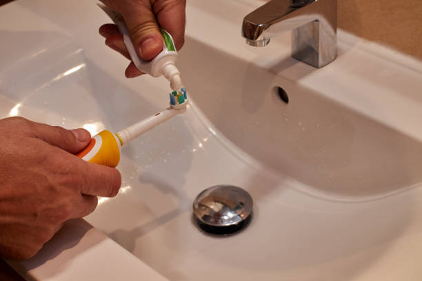istock man putting toothpaste on electric toothbrush 1197283952