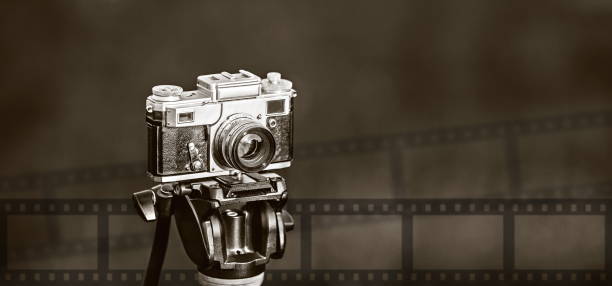 istock retro photo camera on tripod  on dark blurry background 1197284242
