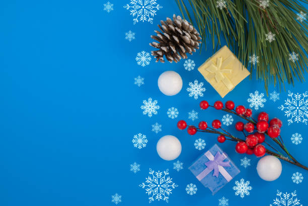 istock Christmas blue background. Gift or present box and holiday decoration top view. pine cone and decorative snowballs, Happy New Year greeting card 1197285249