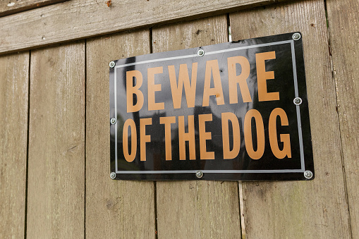 Cuidado con el cartel de perro en la valla de madera photo