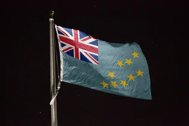 Photo of Tuvalu flag blowing in the wind at night