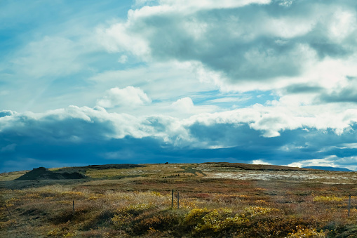 Autumn landscape horiozon over land, impresive dark clouds in the back, Husavik, Iceland
