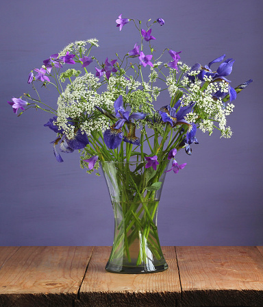 summer bouquet with purple and white flowers in a glass vase.