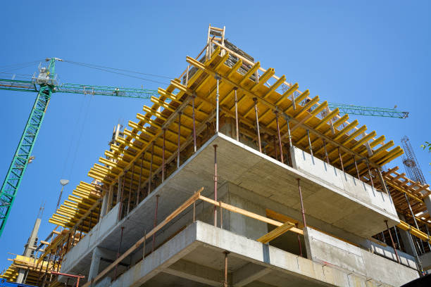 istock Crane and building construction site against blue sky 1197288912