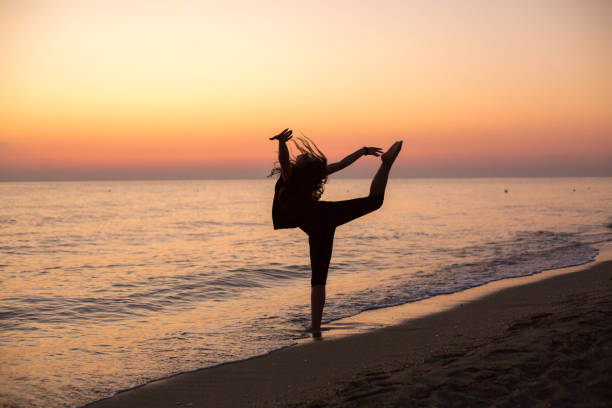 istock Girl dancing on the beach at sunset 1197290333