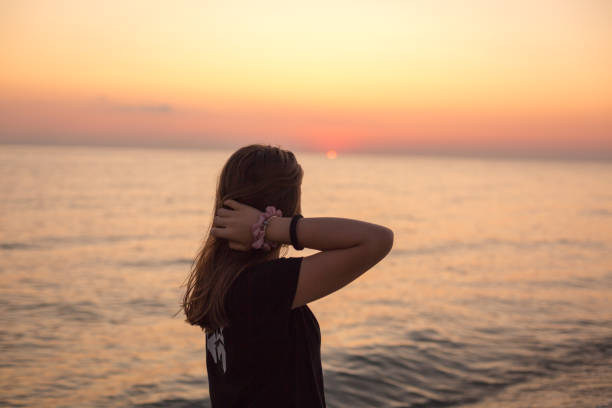 istock Girl enjoying sunset on the beach 1197290936