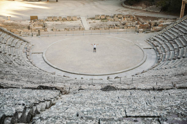 Epidaurus amphitheater One man visiting Epidaurus amphitheater, famous ancient location on Peloponnese, Greece. He is enjoying in amazing acoustic, which is reason why this place famous for. greek amphitheater stock pictures, royalty-free photos & images