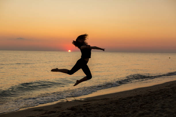 istock Girl dancing on the beach at sunset 1197292106