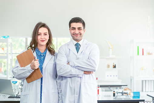 Scientists In Laboratory. Medical Workers At Work. Portrait Of Beautiful Young Woman And Hansome Happy Man In Modern Scientific Laboratory Working Together.